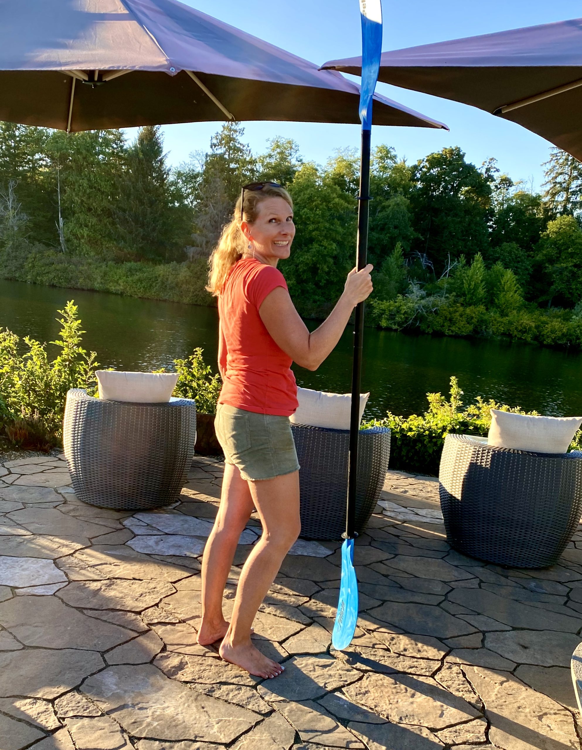 woman with kayak paddle riverside